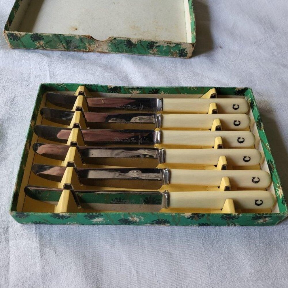 Vintage butter knives with faux bone handles, embossed with "C"